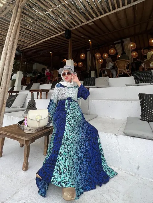 Ia selalu tampil cantik dengan baju panjang dengan motif-motif dan warna cerah. [Instagram @bellashofie_rigan]