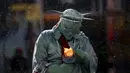 Seorang pria berpakaian seperti "Patung Liberty" memperbaiki lampu yang dipegangnya saat salju turun di Times Square di Manhattan borough New York, (22/1/2016). (REUTERS/Carlo Allegri)