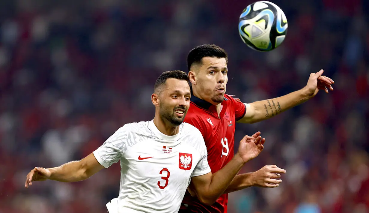 <p>Pemain Polandia Mateusz Wieteska (kiri) berebut bola dengan pemain Albania Mirlind Daku (kanan) pada pertandingan sepak bola Grup E Kualifikasi Euro 2024 di Tirana, Albania, Minggu (10/9/2023). (AP Photo/Franc Zhurda)</p>