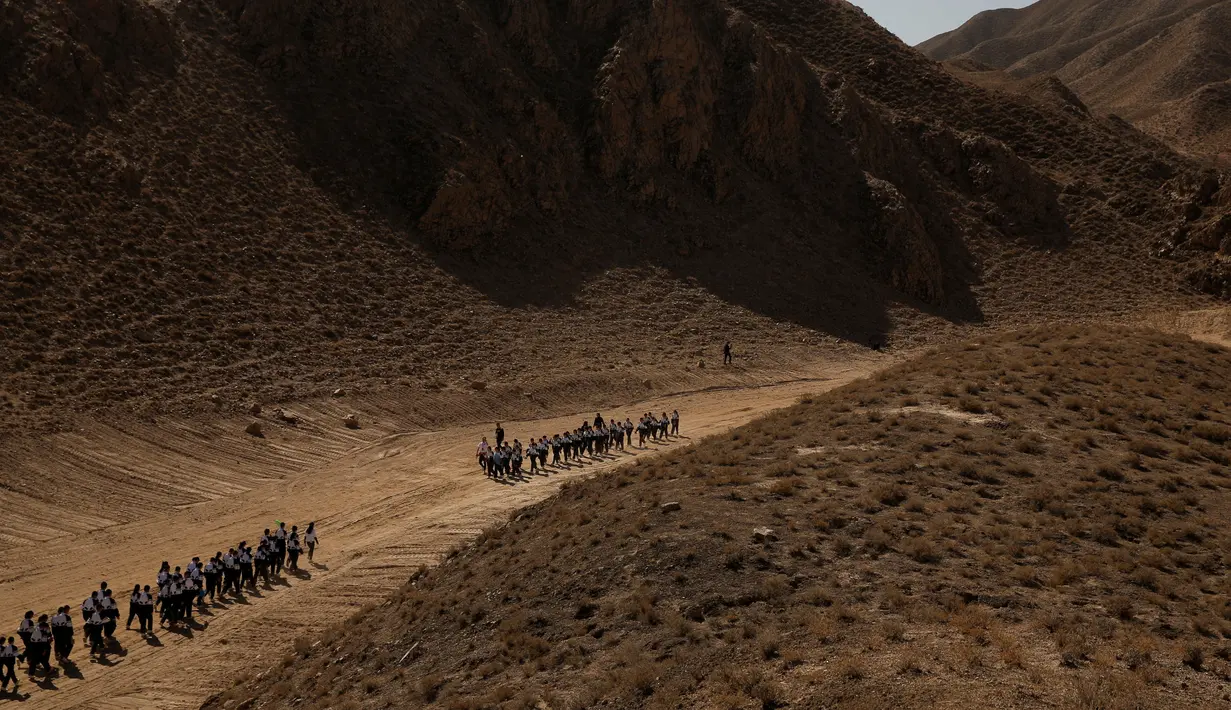 Sejumlah siswa berjalan melintasi Gurun Gobi di dekat pangkalan simulasi C-Space Project Mars di luar Jinchang, Provinsi Gansu, Jinchang, China (17/4). (Reuters/Thomas Peter)