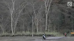 Pengendara motor melintasi kebun yang kering di Desa Besakih, Karangasem, Bali, Jumat (8/12). Erupsi Gunung Agung yang memuntahkan abu vulkanik menyebabkan kawasan Besakih yang sebelumnya hijau menjadi gersang. (Liputan6.com/Immanuel Antonius)