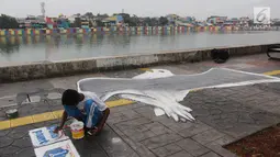 Seorang siswa membuat lukisan mural tiga dimensi berbentuk burung di trotoar jalan di kawasan Danau Sunter, Jakarta, Senin (26/3). Selain itu mural tersebut dibuat untuk dijadikan sebagai objek wisata. (Liputan6/Arya Manggala)