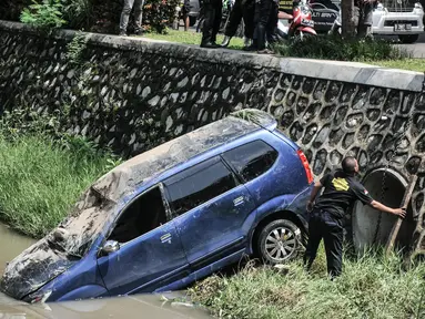 Petugas Dinas Perhubungan Kota Bekasi saat evakuasi mobil yang terperosok ke kali di Harapan Indah, Bekasi, Jawa Barat, Rabu (16/2/2022). Mobil jenis Avanza tersebut jatuh ke dalam kali usai mengalami kecelakaan tunggal akibat tergelincir saat melintasi tikungan. (merdeka.com/Iqbal S. Nugroho)