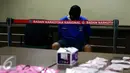 Tersangka AR yang menjadi kurir dihadirkan dalam rilis di kantor BNN, Jakarta, Selasa (27/10/2015). BNN mengamankan empat tersangka kasus narkoba dengan barang bukti 1000 butir pil ekstasi, dua diantaranya merupakan oknum TNI. (Liputan6.com/Yoppy Renato)