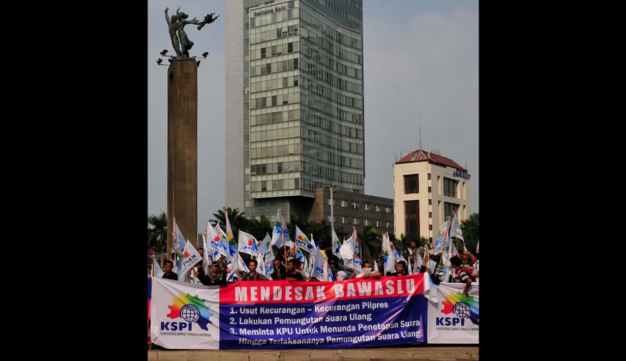  Ratusan massa KSPI di Bundaran HI Jakarta, (22/7/2014), membentangkan spanduk yang berisi tuntutan untuk Komisi Pemilihan Umum (KPU) dan Badan Pengawas Pemilu (Bawaslu). (Liputan6.com/Johan Tallo)