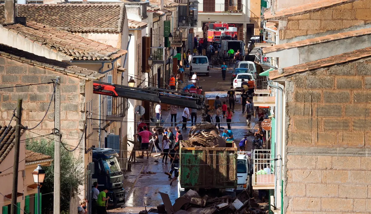 Sejumlah warga membersihkan rumah mereka yang terkena banjir bandang di Sant Llorenc, Mallorca, Spanyol (11/10). Banjir bandang tersebut telah menewaskan setidaknya 10 orang. (AP Photo/Francisco Ubilla)