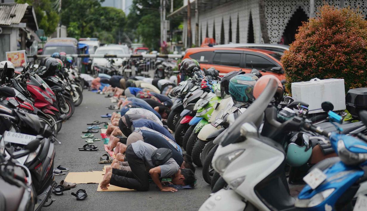 Momen ini menjadi sangat istimewa karena bertepatan dengan hari kedua puasa, di mana umat Islam di Indonesia baru saja memulai perjalanan spiritual mereka di bulan Ramadan. Tampak dalam foto, para pria melaksanakan salat Jumat di antara deretan sepeda motor yang diparkir di luar masjid yang penuh sesak selama bulan suci Ramadan di Jakarta, Jumat 20 Februari 2026. (AP Photo/Dita Alangkara)