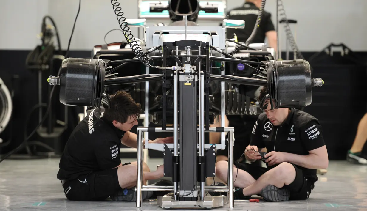Tim Mercedes AMG Petronas terlihat serius mempersiapkan mobil Formula 1 di Sirkuit Sakhir, Bahrain (31/3). jelang Grand Prix F1 Bahrain, Sejumlah tim sibuk mempersiapkan mobil terbaiknya masing-masing. (AFP PHOTO/MOHAMMED AL-SHAIKH)