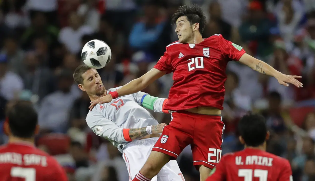 Bek Spanyol, Sergio Ramos, duel udara dengan gelandang Iran, Mehdi Torabi, pada laga grup B Piala Dunia di Kazan Arena, Kazan, Rabu (20/6/2018). Spanyol menang 1-0 atas Iran. (AP/Sergei Grits)