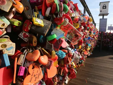 Sepasang pengunjung berswafoto dekat pagar yang dipenuhi gembok cinta di Namsan Seoul Tower, Korea Selatan, Selasa (29/1). Mitosnya, pasangan yang mengaitkan gembok cinta dan membuang kuncinya ke bawah akan menjadi pasangan abadi. (AP/Ahn Young-joon)