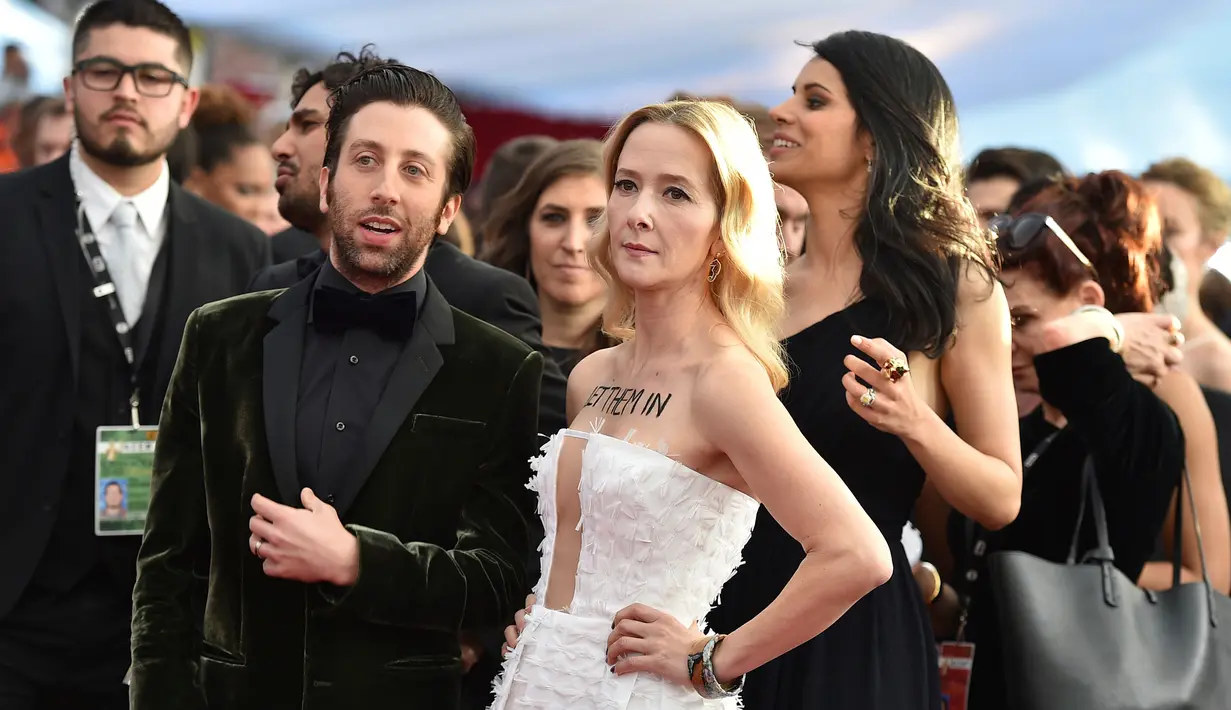 Aktor Simon Helberg dan Jocelyn Towne setibanya di ajang SAG Awards di Los Angeles, Minggu (29/1). Di ajang itu, sejumlah selebriti menunjukkan keberatannya atas kebijakan Donald Trump yang menghentikan program pengungsi di AS (Jordan Strauss/Invision/AP)