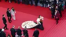 Mantan Miss World ini melenggang di atas karpet merah dengan gaun hitam dan putih dengan corak keemasan. (Sameer Al-DOUMY / AFP)