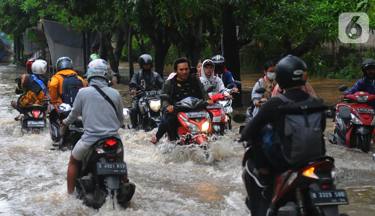 Sejumlah pengendara motor melintasi banjir di Jalan Benteng,  Duta Kranji, Kalibaru, Bekasi, Jawa Barat, Jumat (24/2/2023). Jalan yang dilalui oleh para pengendara masih digenangi air ditambah dari luapan kalibaru Duta Kranji akibat hujan deras yang mengguyur Kota Bekasi sejak Kamis (23/2/2023) malam. (merdeka.com/Imam Buhori)