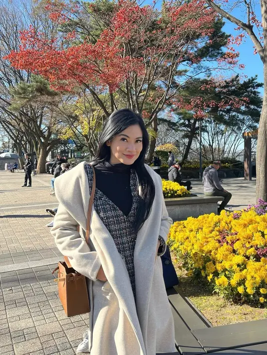 Pada potret pertama, Titi Kamal tampil dengan outfit dua lapis. Ia memadukan turtleneck top hitam dengan tweed blazer dan wool coat. Penampilannya dilengkapi dengan sling bag Hermes warna coklat muda. [@titi_kamall]