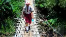 Para siswa SD ini terbiasa melewati jembatan gantung di atas kali Ciliwung untuk menuju ke sekolah, Jakarta, Selasa (17/3/2015). Padahal jembatan tersebut sangat membahayakan dan berisiko (Liputan6.com/Yoppy Renato)