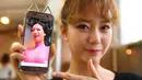 Personel girlband Six Bomb, Hong Hye-Jin atau So-Ah, menunjukkan foto dirinya sebelum menjalani operasi plastik di sebuah salon kecantikan di Seoul, Korsel, 16 Maret 2017. Seul-Bee menjalani operasi plastik pada bagian hidungnya. (YELIM LEE/AFP)