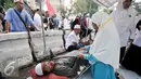 Seorang demonstran yang kelelahan diberikan pertolongan, Jakarta, Jumat (4/11). Massa yang datang ke posko ini rata-rata yang usianya sudah separuh baya, di atas 45 tahun. (Liputan6.com/Yoppy Renato)