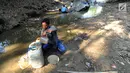 Warga mengambil air dari lubang pada aliran Sungai Cihoe untuk memenuhi kebutuhan sehari-hari termasuk air minum di kawasan Ridogalih, Cibarusah, Bekasi, Minggu (7/7/2019). Sudah lebih dari dua bulan, warga memanfaatkan sisa aliran sungai yang kotor akibat musim kemarau. (merdeka.com/Arie Basuki)
