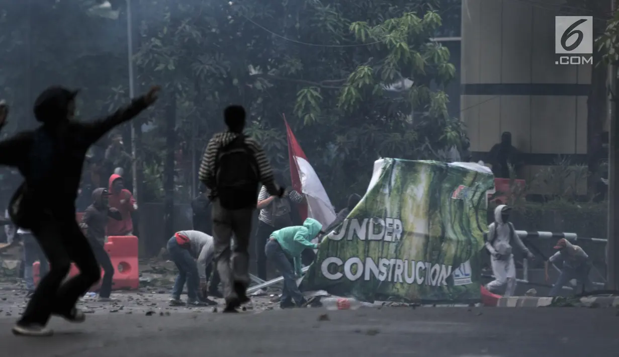 Massa aksi melemparkan batu ke arah polisi di dekat Gedung BPK RI, Gatot Subroto, Senin (30/9/2019). Buntut dari kerusuhan itu, aparat kepolisian melepaskan tembakan gas air mata guna membalas serangan petasan yang dilemparkan para pengunjuk rasa. (merdeka.com/Iqbal Nugroho)