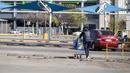 El Mencho tewas saat dalam perjalanan udara menuju Mexico City. Tampak dalam foto, seorang pria mendorong troli belanja melalui tempat parkir sebuah toko yang tutup di Morelia, negara bagian Michoacan, Meksiko, pada 23 Februari 2026. (Enrique Castro/AFP)