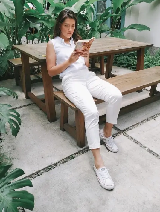 Serba putih dari mulai atasa, celana hingga sepatu membuat Monita semakin elegan. Ditambah lagi dengan posenya sedang membaca buku. (Liputan6.com/Instagram/@monitatahalea)