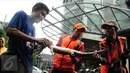 Petugas mengikat seekor biawak yang ditemukan di saluran air ketika banjir melanda kawasan Kemang, Jakarta Selatan, Selasa (4/10). Biawak itu diduga terbawa banjir di kawasan Kemang akibat luapan air Kali Krukut. (Liputan6.com/Gempur M Surya)