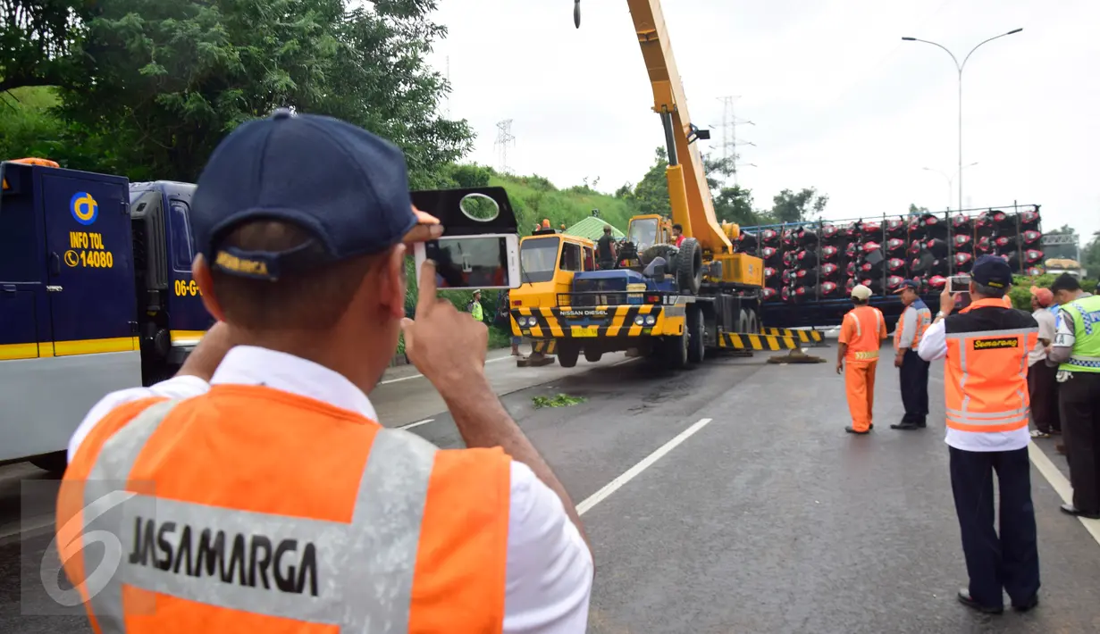 Sejumlah petugas berada di lokasi kejadian truk yang terguling di Ruas Tol  KM 10 Kota Semarang, Jawa Tengah, Senin (6/3). (Liputan6.com/Gholib)