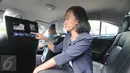 Seorang wanita menunjukkan layar In-Taxi Intertaiment (ITE) yang berada di dalam taksi Blue Bird, Jakarta, Rabu (18/11/2015). Kehadiran ITE diharapkan dapat memperkaya pengalaman serta hiburan kepada penumpang. (Liputan6.com/Angga Yuniar)