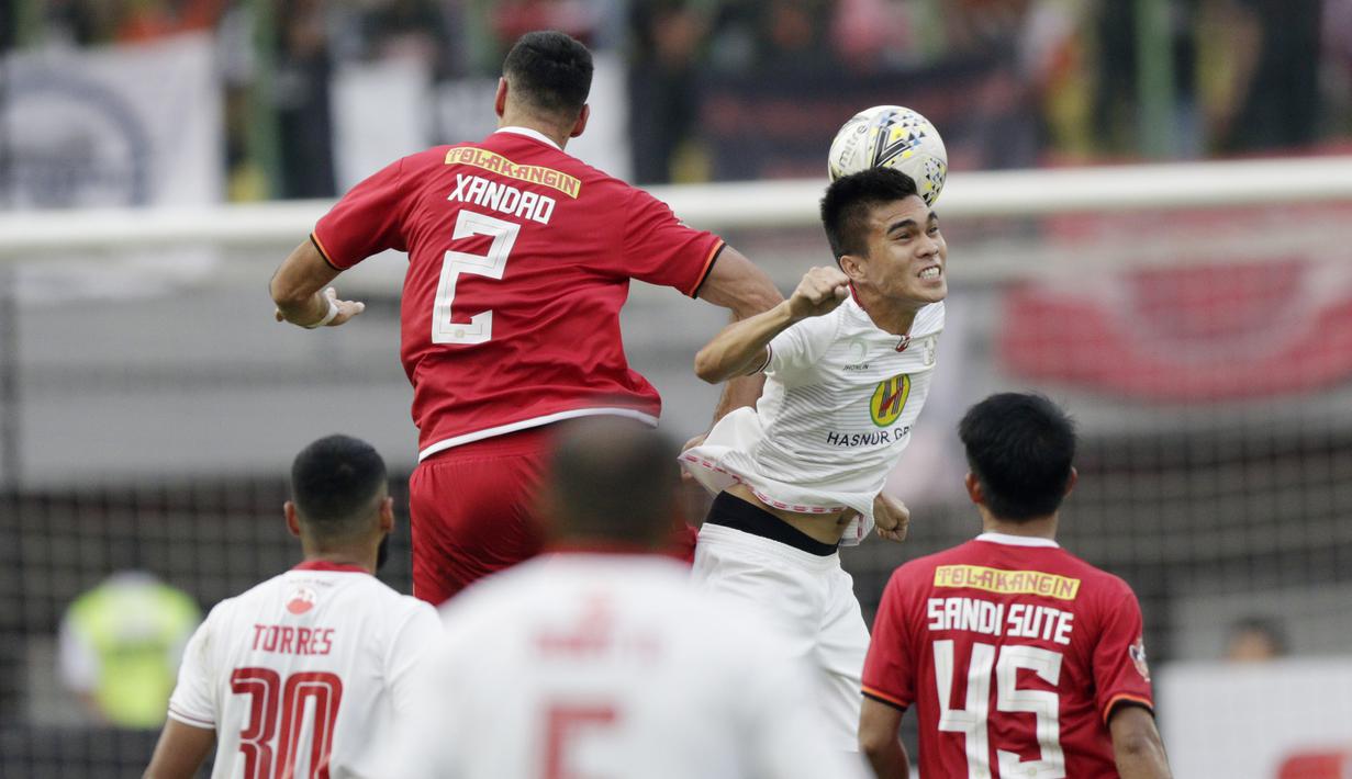 Bek Persija Jakarta, Xandao, duel udara dengan gelandang Barito Putra, Paulo Sitanggang, pada laga Liga 1 2019 di Stadion Patriot, Bekasi, Senin (23/9/2019). Persija menang 1-0 atas Barito Putra. (Bola.com/M Iqbal Ichsan)