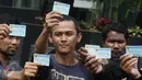 Aktivis Koalisi Masyarakat Sipil menunjukan KTP Elektronik saat melakukan aksi di depan Gedung KPK, Jakarta, Minggu (12/3). Aksi ini bertujuan untuk menuntut agar KPK mengusut tuntas kasus mega korupsi KTP Elektronik. (Liputan6.com/Immanuel Antonius)