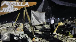 Warga Pasar Ikan menunaikan shalat di atas musholah yang telah diratakan saat penggusuran, Jakarta, Jumat (29/4/2016). Sebagian warga memilih bertahan di perahu atau tenda pengungsian. (Liputan6.com/Yoppy Renato)