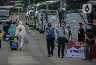 Petugas dengan menggunakan pengeras suara memberikan arahan kepada peserta Mudik Aman Mudik Sehat Kementerian Perhubungan di Terminal Jatijajar, Depok, Jawa Barat, Kamis (28/4/2022). Pengguna jasa transportasi bus yang mengikuti program mudik gratis didominasi oleh pemudik yang berasal dari Jawa Tengah dan Jawa Timur dengan syarat telah menerima vaksin booster. (Liputan6.com/Faizal Fanani)
