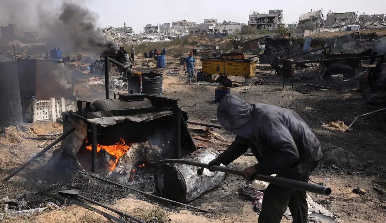 Seorang pria Palestina bekerja di pabrik darurat yang mengekstraksi Bahan Bakar Minyak (BBM) dari plastik daur ulang di Jabalia di Jalur Gaza utara pada 6 April 2025. (BASHAR TALEB/AFP)