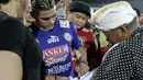 Cristian Gonzales melayani permintaan tanda tangan oleh salah satu fans, dikawal oleh bodyguard seusai bertanding melawan Mitra Kukar, Sabtu (17/10/2015). (Bola.com/Erwin Fitriansyah)