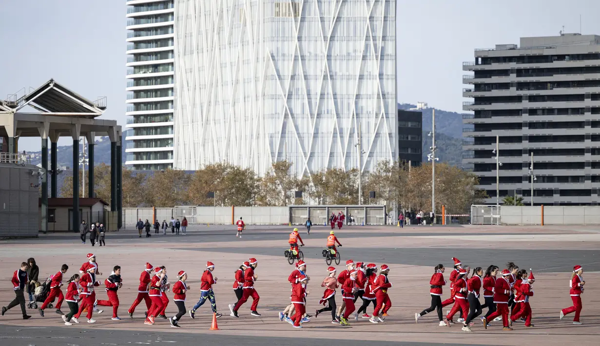 Sejumlah pelari berkostum Sinterklas melewati jalanan Barcelona Spanyol dalam acara fun run 5 km pada Minggu (22/12/2024) waktu setempat. (AFP/Josep Lago)