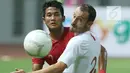 Bek Timnas Indonesia, Putu Gede Juni Antara (kiri) berebut bola dengan pemain Hong Kong, Daniel C Rodriguez pada laga uji coba internasional di Stadion Wibawa Mukti, Cikarang, Selasa (16/10). Laga berakhir imbang 1-1. (Liputan6.com/Helmi Fithriansyah)