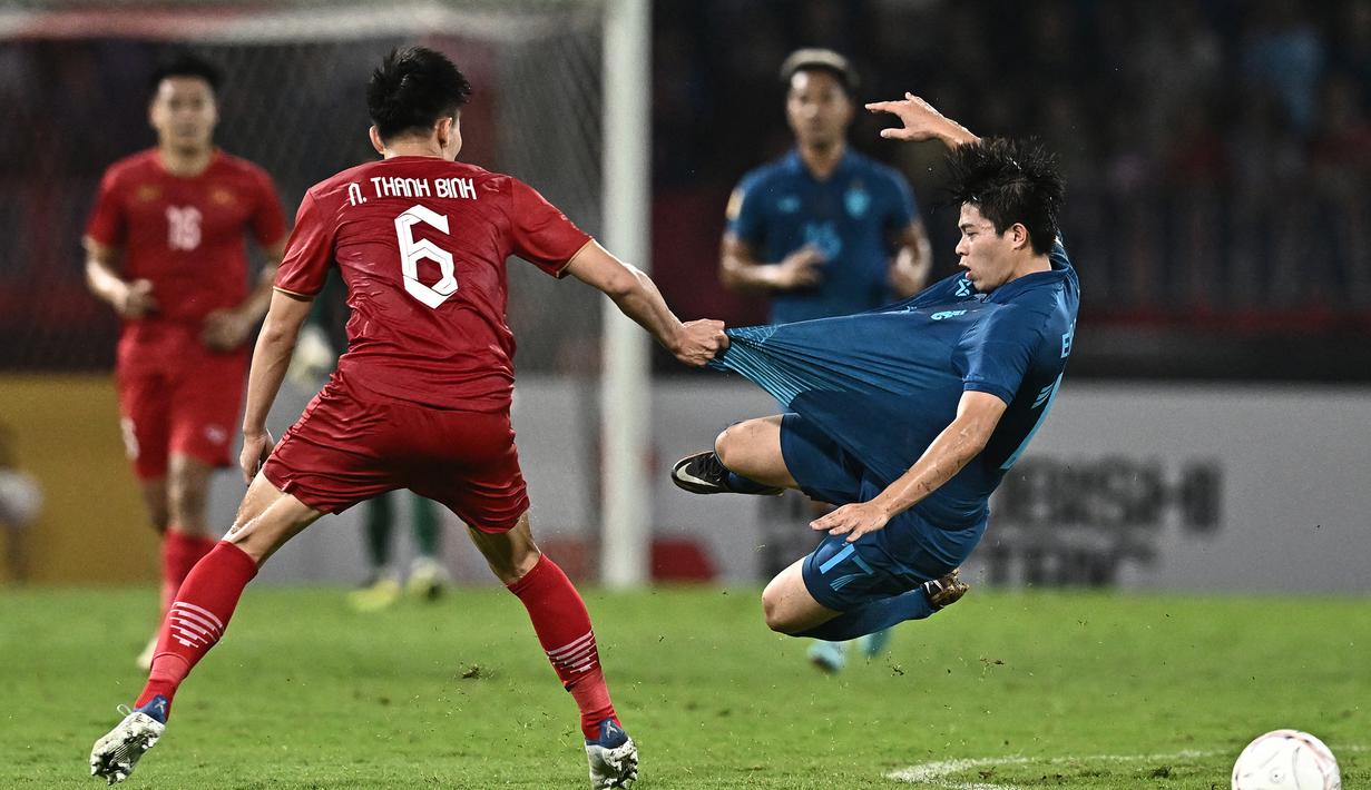 Pemain Thailand, Ekanit Panya (kanan) dilanggar pemain Vietnam, Nguyen Thanh Binh pada laga final Piala AFF 2022 di Thammasat Stadium, Bangkok, Thailand (16/1/2023). Bersama Timnas Thailand, Ekanit Panya telah mengoleksi 17 caps dengan torehan 1 gol dan 4 assist sejak melakukan debut pada 10 September 2019. (AFP/Lillian Suwanrumpha)