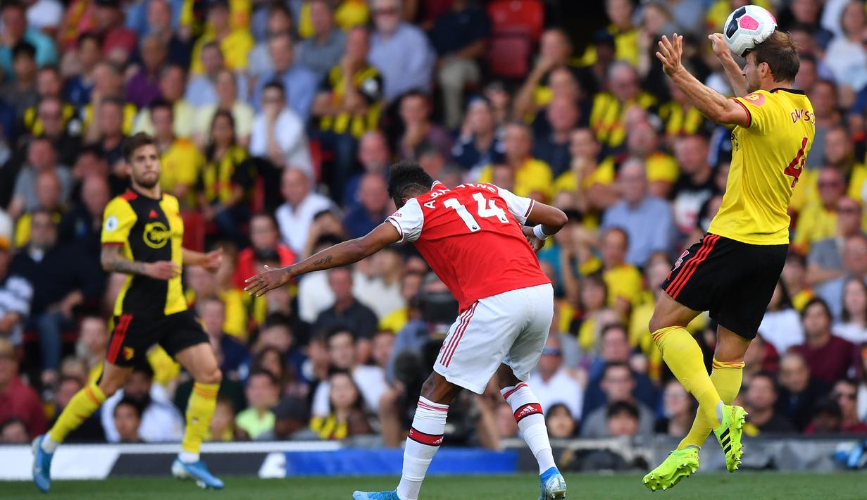 Bek Watford, Craig Dawson, berebut bola dengan striker Arsenal, Pierre-Emerick Aubameyang, pada laga Premier League 2019/20 di Stadion Vicarage Road, Watford, Minggu (15/9). Kedua klub bermain imbang 2-2. (AFP/Ben Stansall)