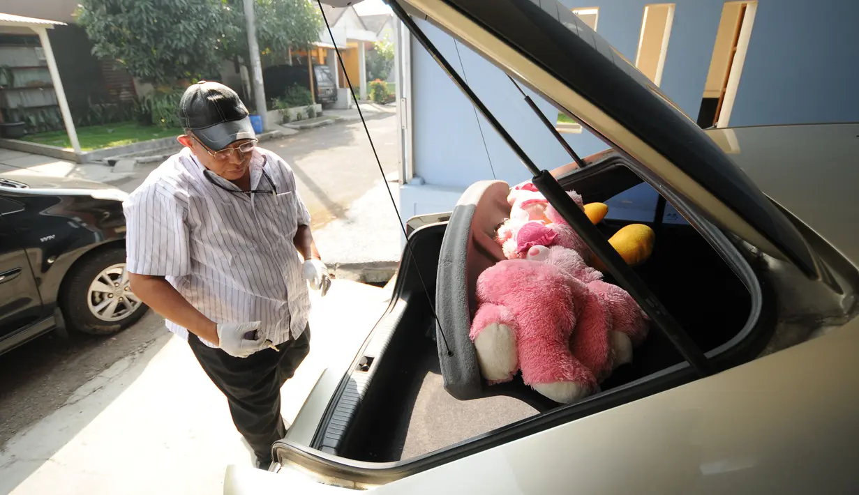 Petugas Dir Tipikor Bareskrim Mabes Polri memeriksa mobil yang terparkir di rumah Yayat A Sudrajat tersangka kasus dugaan korupsi proyek pembangunan Stadion Gedebage di Sarie Bunga Bakung D25, Bandung, Jumat (22/5/2015). (Liputan6.com/Helmi Fithriansyah)