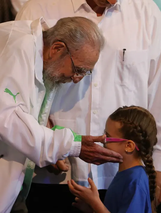  Mantan presiden Kuba Fidel Castro memegang pipi seorang anak kecil dalam acara gala budaya perayaan ulang tahun Fidel Castro yang ke-90 di Havana , Kuba, (13/8). (Miraflores Palace/Reuters)   