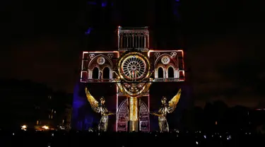 Seni pertunjukan cahaya hiasi Gereja Katedral Notre-Dame de Paris, Prancis (11/11). Pertunjukan cahaya ini dalam rangka peringatan Hari Gencatan Senjata yang menandai berakhirnya Perang Dunia I. (AFP Photo/Francois Guillot)