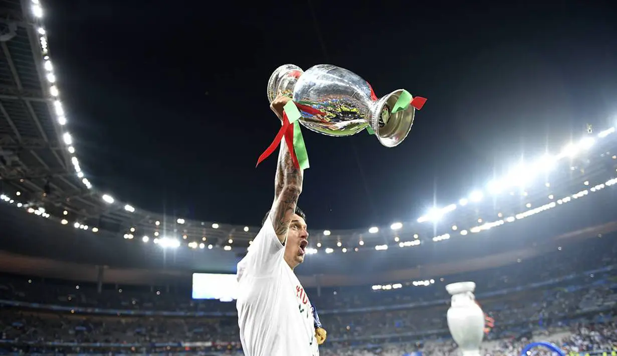 Bek Portugal, Fonte, mengangkat trofi juara Piala Eropa 2016, Senin (11/7/2016) dini hari WIB. (AFP/Martin Bureau)