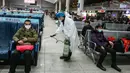 Petugas menyemprotkan cairan disinfektan di Stasiun Kereta Api Yingtan di Nanchang di Provinsi Jiangxi Tengah, China (22/1/2020). Penyemprotan dilakukan untuk mencegah virus corona menyebar ke kota lain. (AFP Photo/STR)