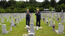 Warga Korea Selatan Choe Geun-ho dan Choe In-suck (kiri) berdoa di depan nisan paman mereka Choe Hyun-jun yang gugur saat Perang Korea pada peringatan Hari Pahlawan di Pemakaman Nasional Seoul, Seoul, Korea Selatan, Senin (6/6/2022). (AP Photo /Ahn Young-joon)