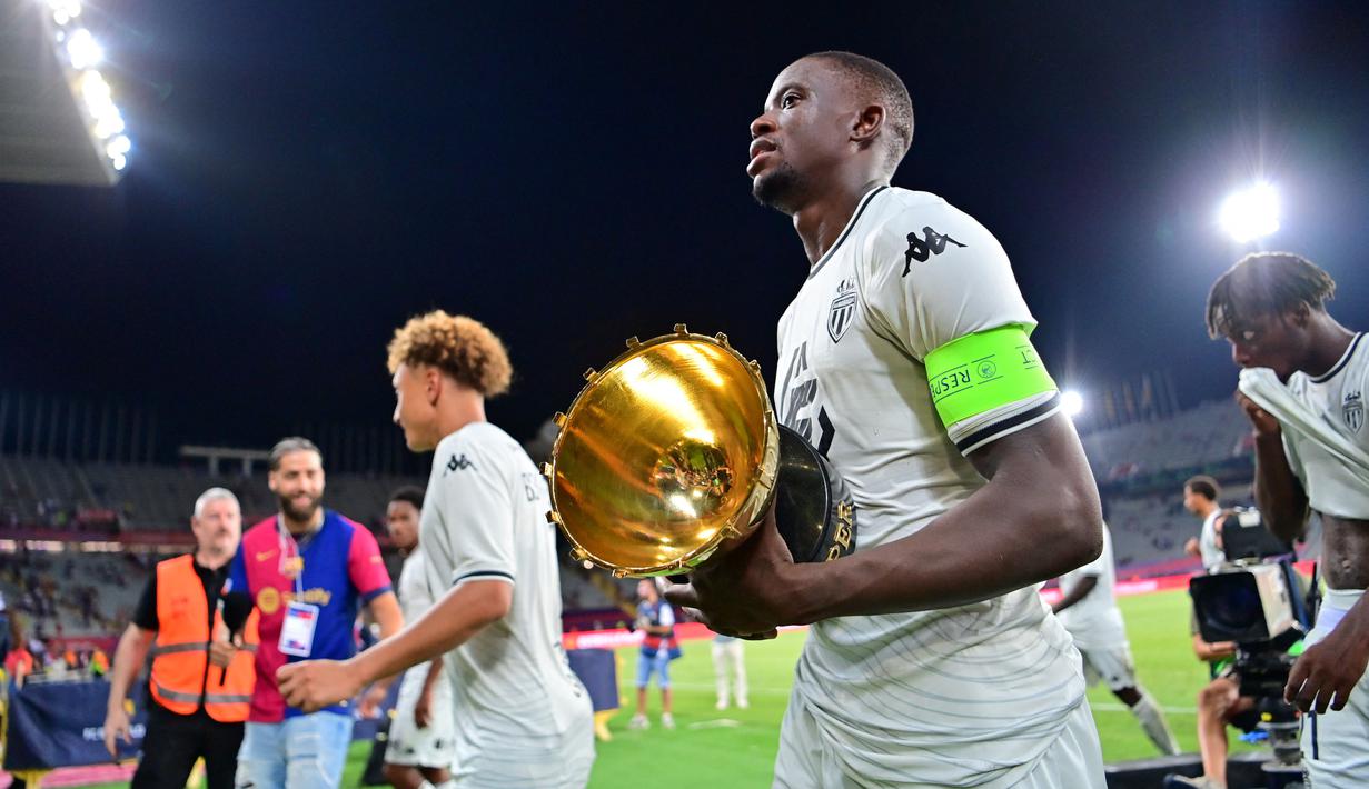 Pemain AS Monaco, Denis Zakaria, membawa trofi setelah menjuarai Joan Gamper Trophy di Estadi Olimpic Lluis Companys, Selasa (13/8/2024) dini hari WIB. (AFP/Manaure Quintero)