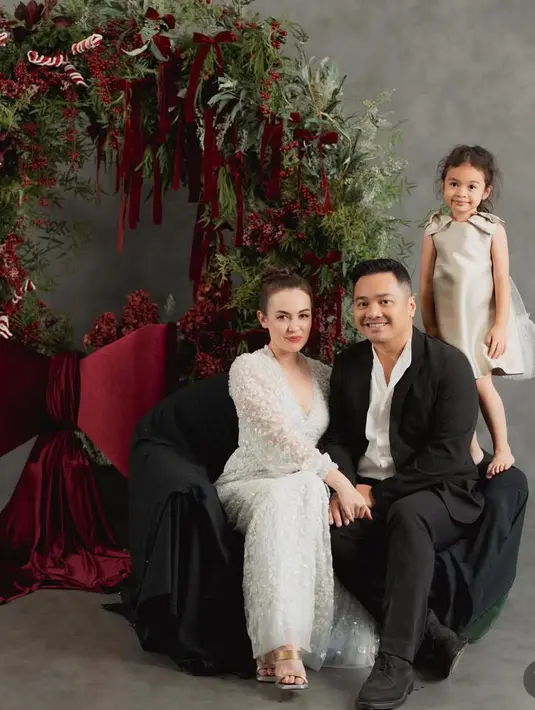 Rianti Cartwright  juga membagikan foto natal tahun ini bersama suami dan putrinya di depan pohon natal unik. Rianti tampil dengan dress putih model kerah v neck. [@riantic]