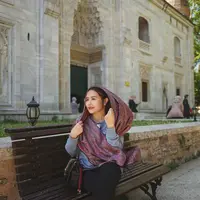 Setelah Lebaran, Prilly Latuconsina tampaknya memilih menikmati waktu liburnya ke Turki. Dalam foto ini, ia terlihat berpose duduk di bangku berlatar sebuah bangunan, mengenakan kemeja biru lengan panjang, legging hitam, dan syal panjang untuk menutupi rambutnya. Ia juga terlihat membawa sling bag berwarna hitam. Foto: Instagram.