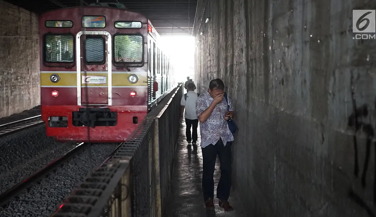 Pejalan kaki melintasi jalan setapak di sekitar Stasiun Cawang, Jakarta, Kamis (9/5). Meskipun sempit, jalan setapak tersebut masih menjadi pilihan sebagian pejalan kaki untuk menyeberangi Jalan Gatot Soebroto, dibanding harus melewati JPO yang jaraknya lebih jauh. (Liputan6.com/Immanuel Antonius)