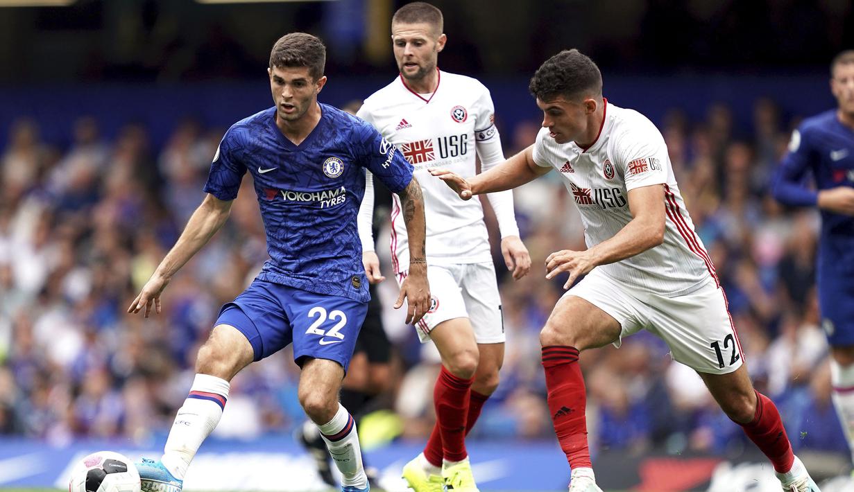Gelandang Chelsea, Christian Pulisic, berusaha melewati bek Sheffield United, John Egan, pada laga Premier League di Stadion Stamford Bridge, London, Sabtu (31/8). Kedua klub bermain imbang 2-2. (AP/John Walton)