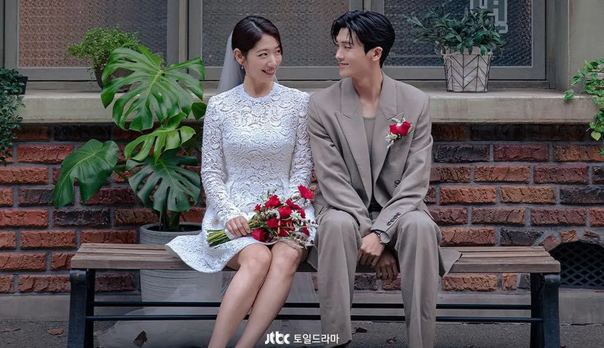 Dipadukan dengan stiletto heels. Sementara itu, Park Hyun Sik mengenakan setelan jas warna coklat lengkap dengan bros mawar merah.[@jtbcdrama]